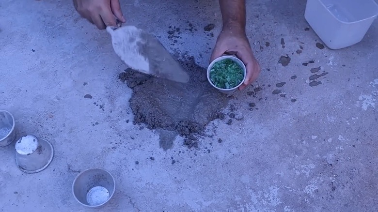 Person adding glass shards to mortar mixture
