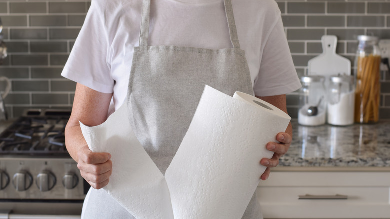 woman pulling paper towel off roll