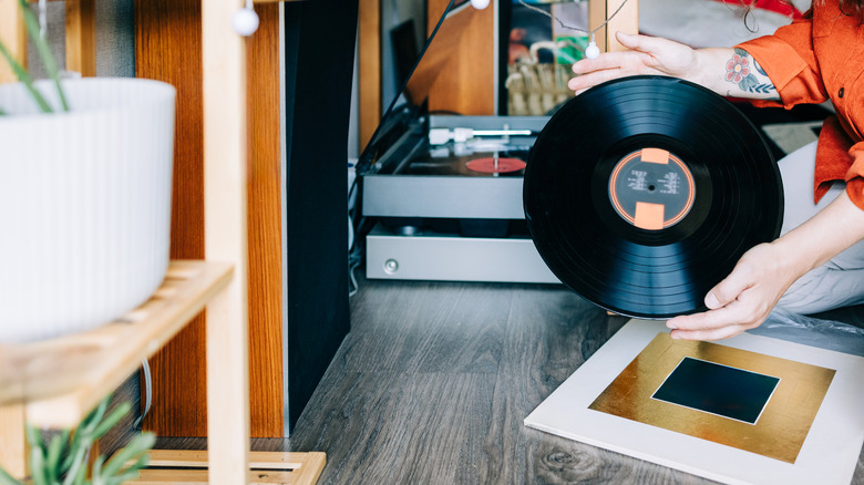 A woman's hands holding a vinyl record.