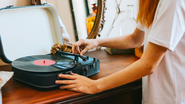 Person playing vinyl record on record player