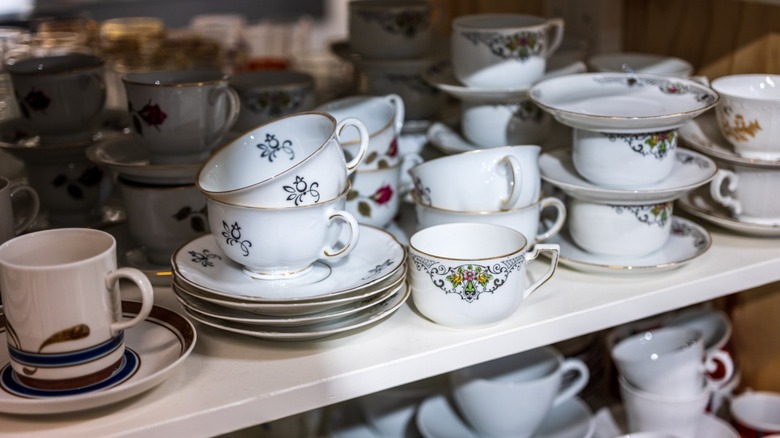 A bunch of vintage teacups stacked together.