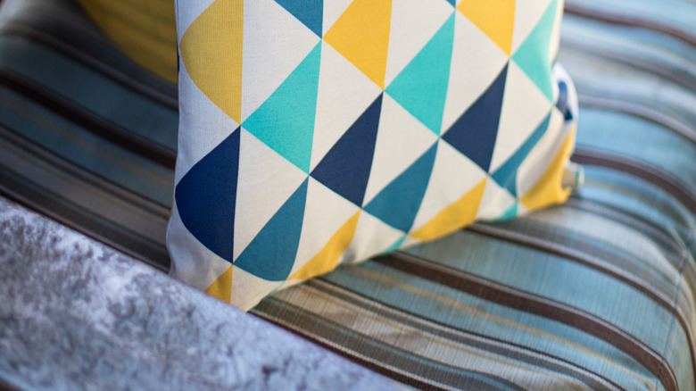 A yellow, blue, white, and teal triangle patio couch cushion