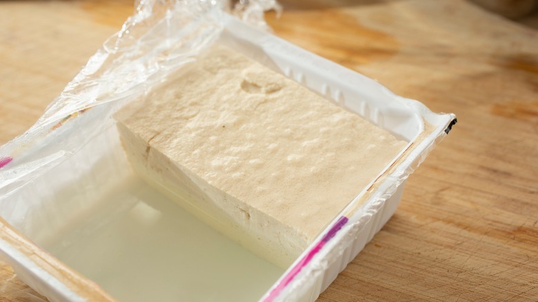 Half-empty tofu container on counter