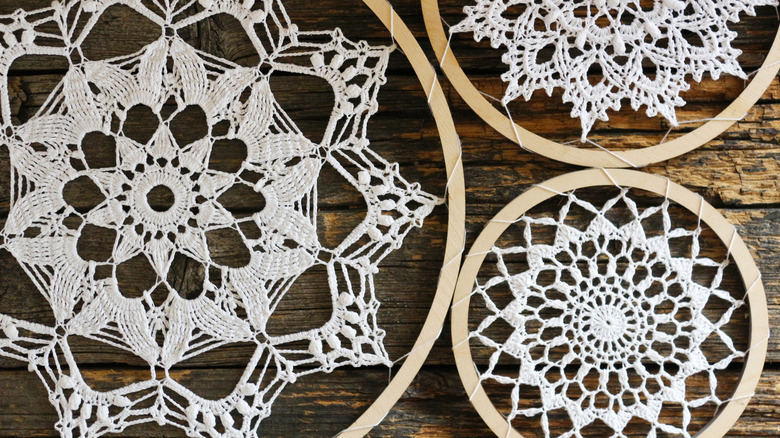 Three doilies fastened to hoops on a wood table