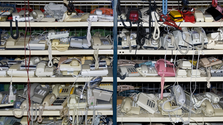Collection of old phones on shelves in a store