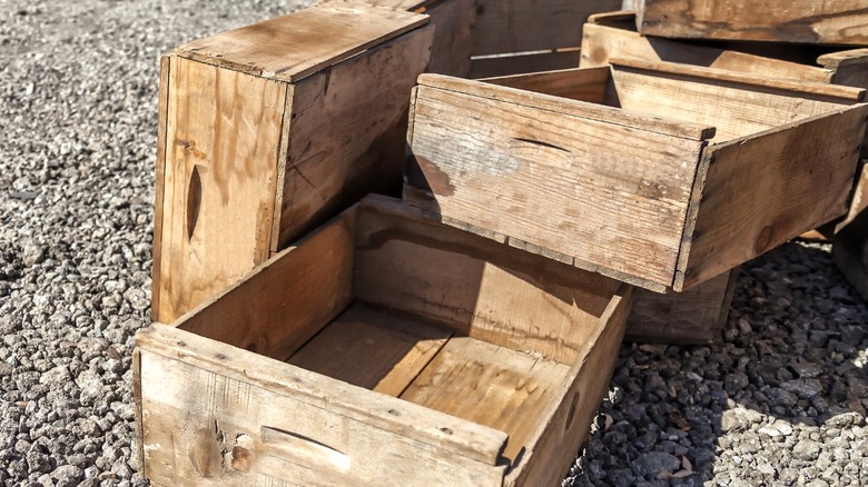 Empty wood crates piled on gravel plot