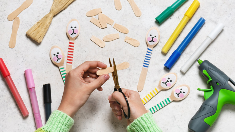 Person making crafts out of wooden spoons