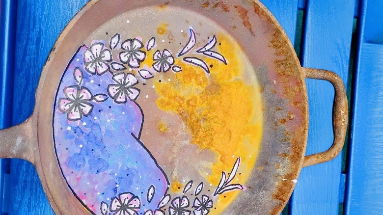 Floral design painted onto old cast-iron pan.