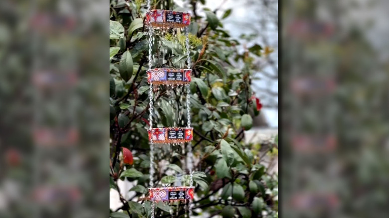 Upcycled sardine cans connected with chains are used as a rain chain.