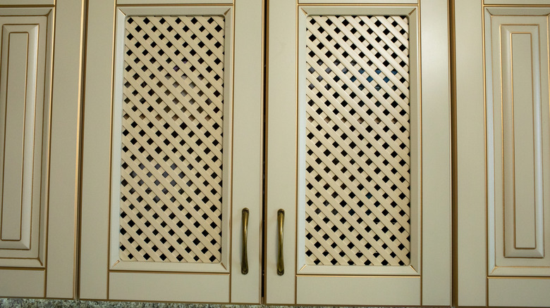 Close up of a kitchen cabinet with lattice inserts.