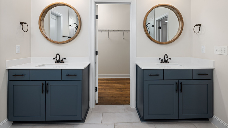 A pair of blue vanities flanking a closet door