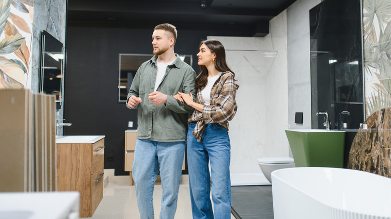 Two people shopping for bathroom fixtures and finishes in a showroom