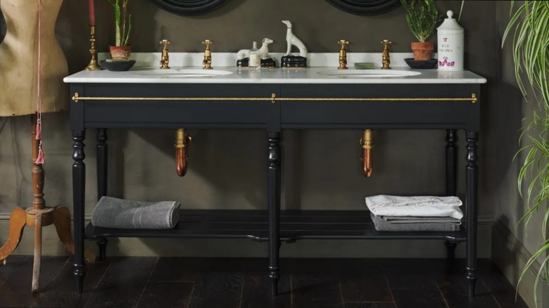 A black washstand in a moody bathroom