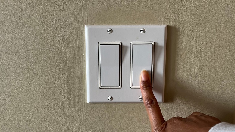 hand turning on light switch