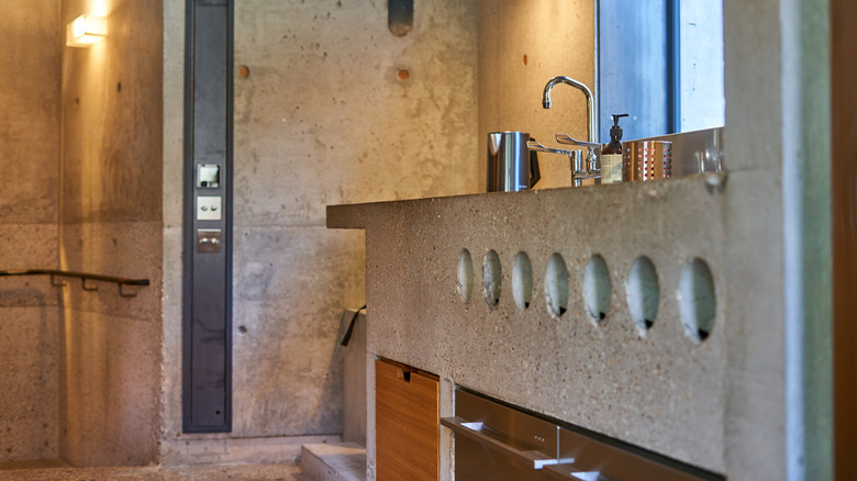 An industrial-style bathroom with cement countertops.