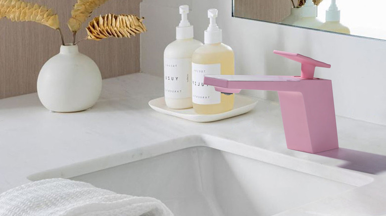 A futuristic pink bathroom faucet.