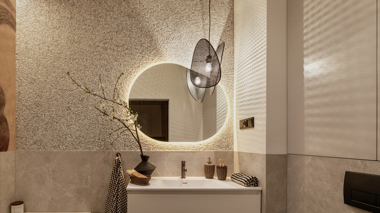 A contemporary bathroom with a sculptural pendant light.