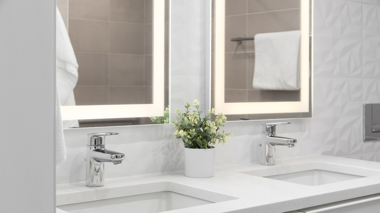 Two modern sinks with LED mirrors.