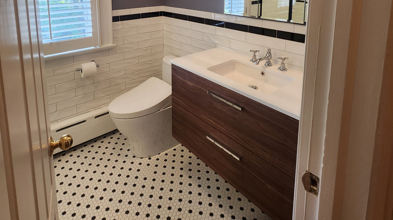 A bathroom with penny tiles and a dark wood vanity.