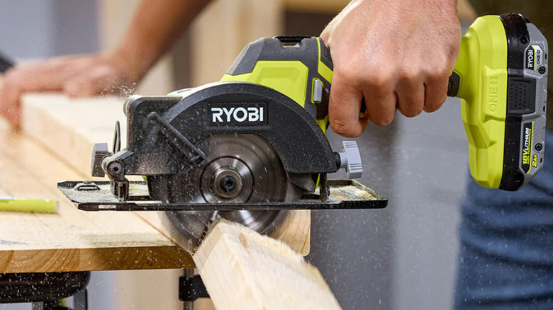 A man using Ryobi's 18V One+ 4½-inch Circular Saw Kit to cut lumber