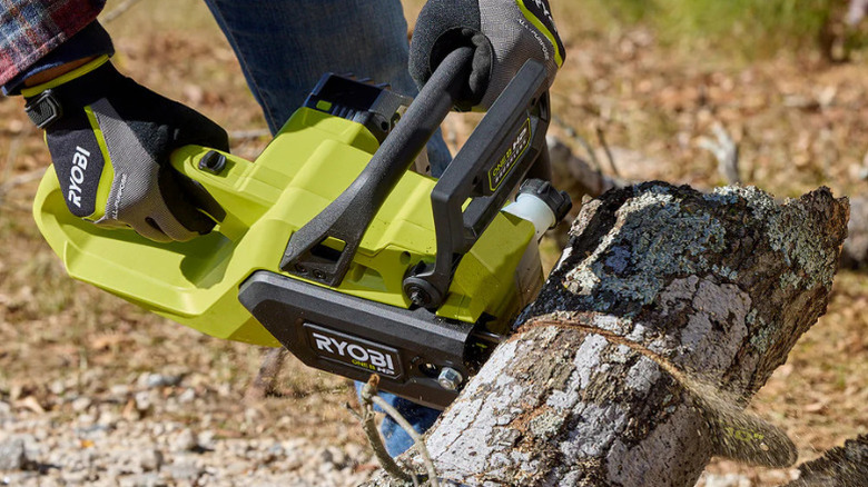 Close-up of a person using Ryobi's 18V One+ HP Brushless 10-inch Chainsaw Kit