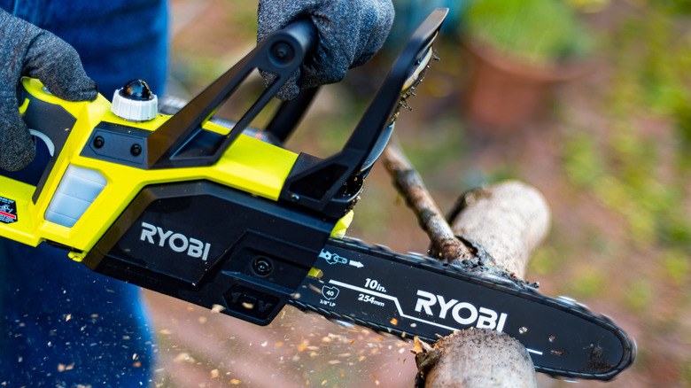 Close-up of a person using a Ryobi saw