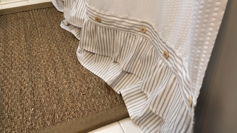The bottom edge of a shower curtain with a coastal farmhouse-style ruffle added to the bottom.