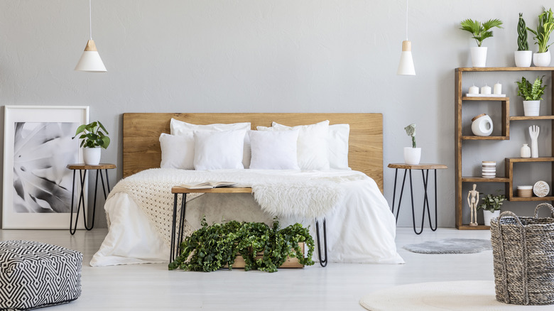 Wooden headboard on a bed with white bedding and various decor pieces around it