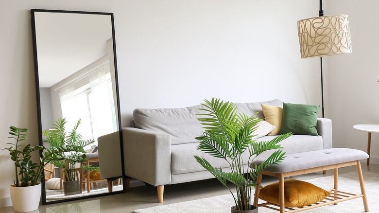 floorlength mirror beside grey couch