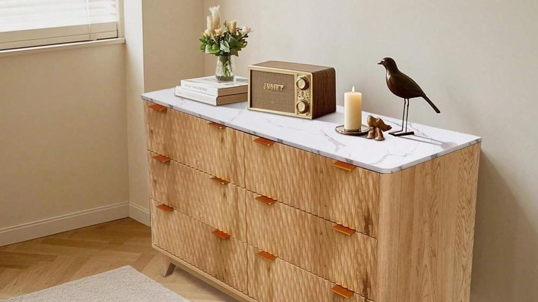 Wood dresser with a white and gray marble top.