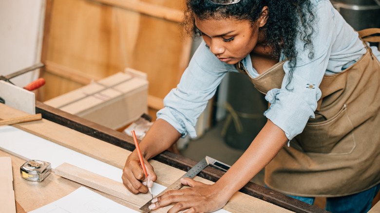 Person measuring wood pieces for a DIY