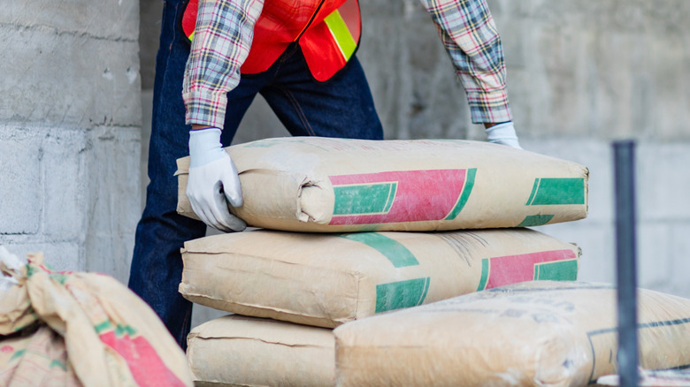Man stacking up concrete bags.