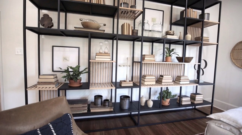 A big white sofa backing onto three tall windows.