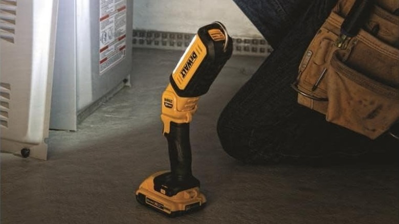 DeWalt 20V MAX LED Work Light next to a person working in a basement