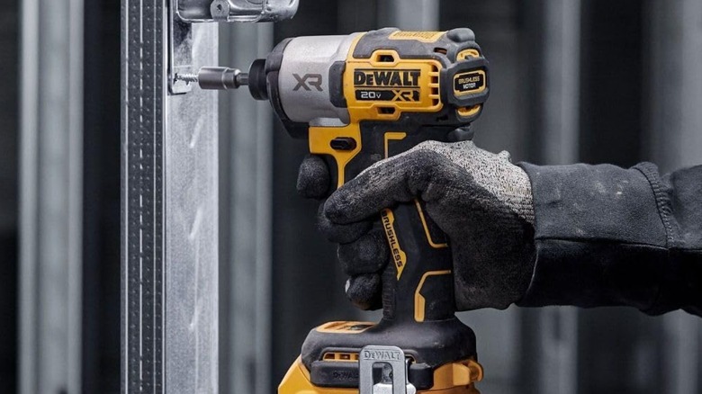 DeWalt 20V MAX XR Impact Driver being used to attach a bracket to a metal post
