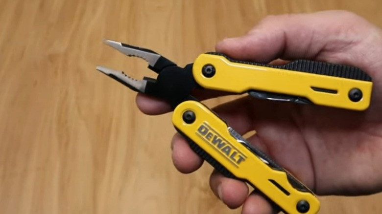 Hand holding DeWalt MT16 Multi-Tool to show plier function