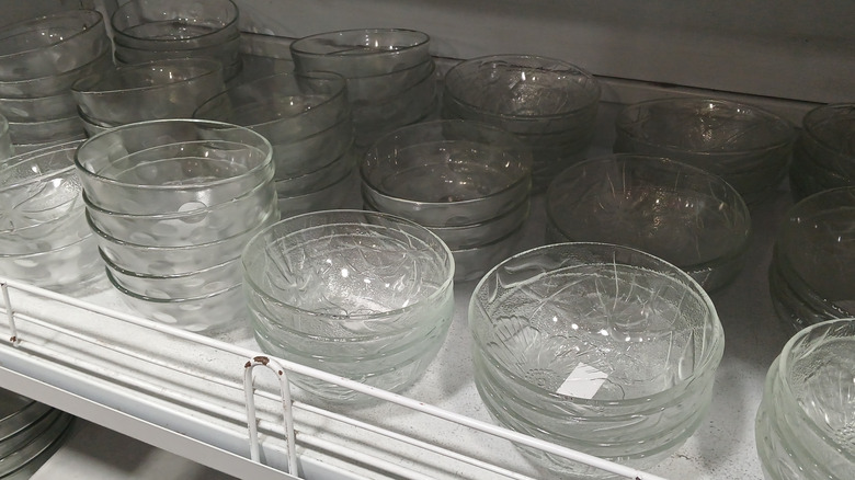Glass bowls nested within each other on a white shelf in a store