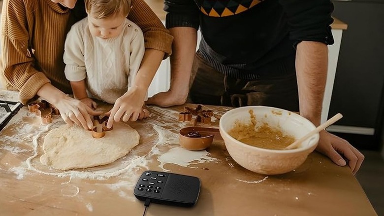 Intercom sitting on a table where a child and his mom are baking