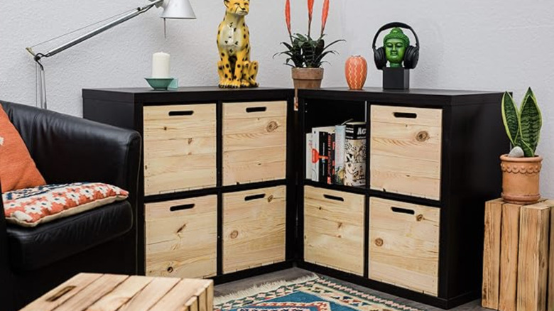 Two black cube organizers containing wood-faced storage bins.