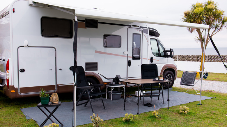 An RV with the outdoor seating area set up.