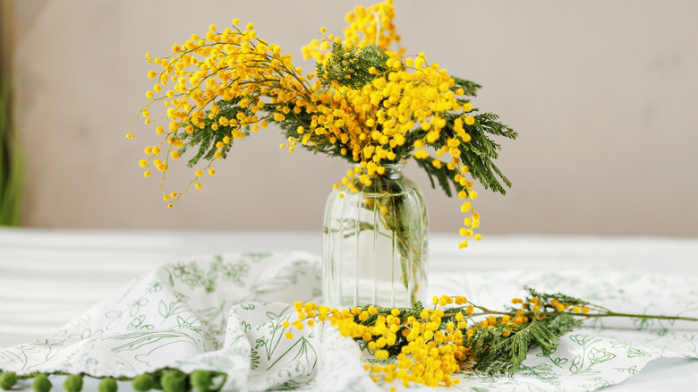 Yellow flowers in clear glass vase table
