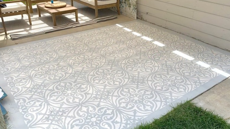Solid stenciled patio slab with patio furniture nearby.