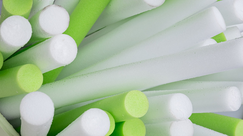 Assorted white and green pool noodles