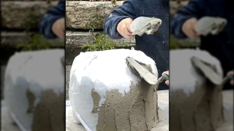 Demonstrator applying cement mixture while constructing DIY planter