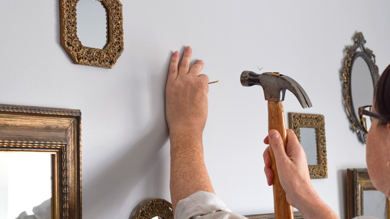 A man hanging a gallery wall