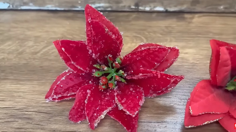 Borax-crystal frosted fake poinsettia flowers on a wooden table