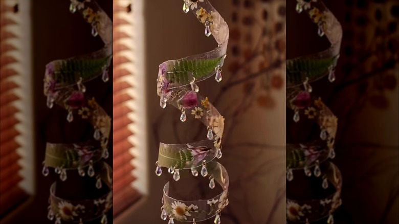 A plastic bottle suncatcher made with pressed flowers and beads