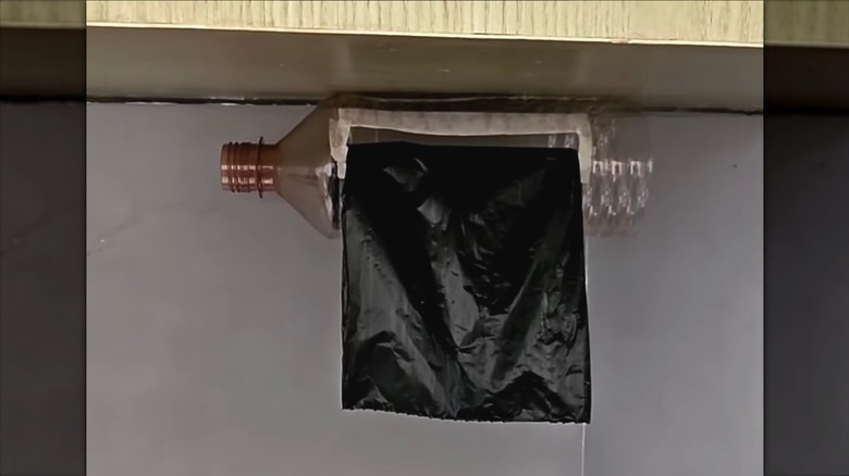 Plastic bottle turned into a trash bag dispenser