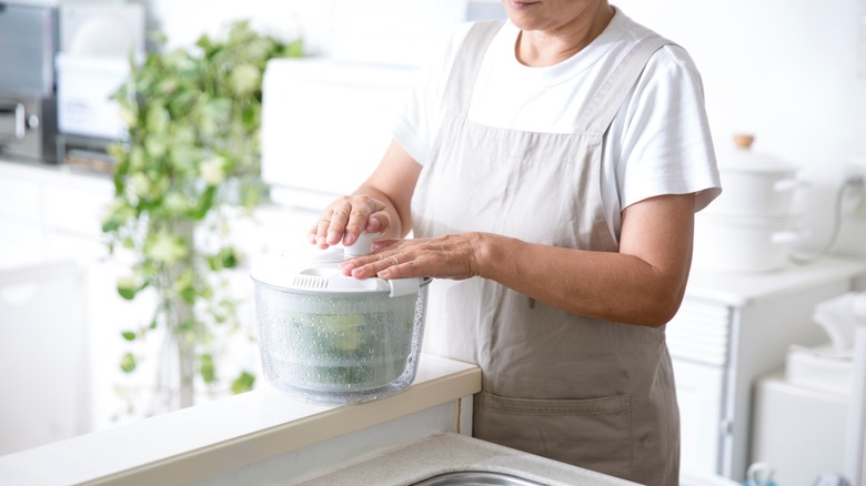 Someone using a salad spinner