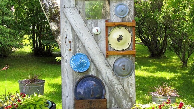 A set of ancient pans and kitchenware from the old days displayed on a wall.